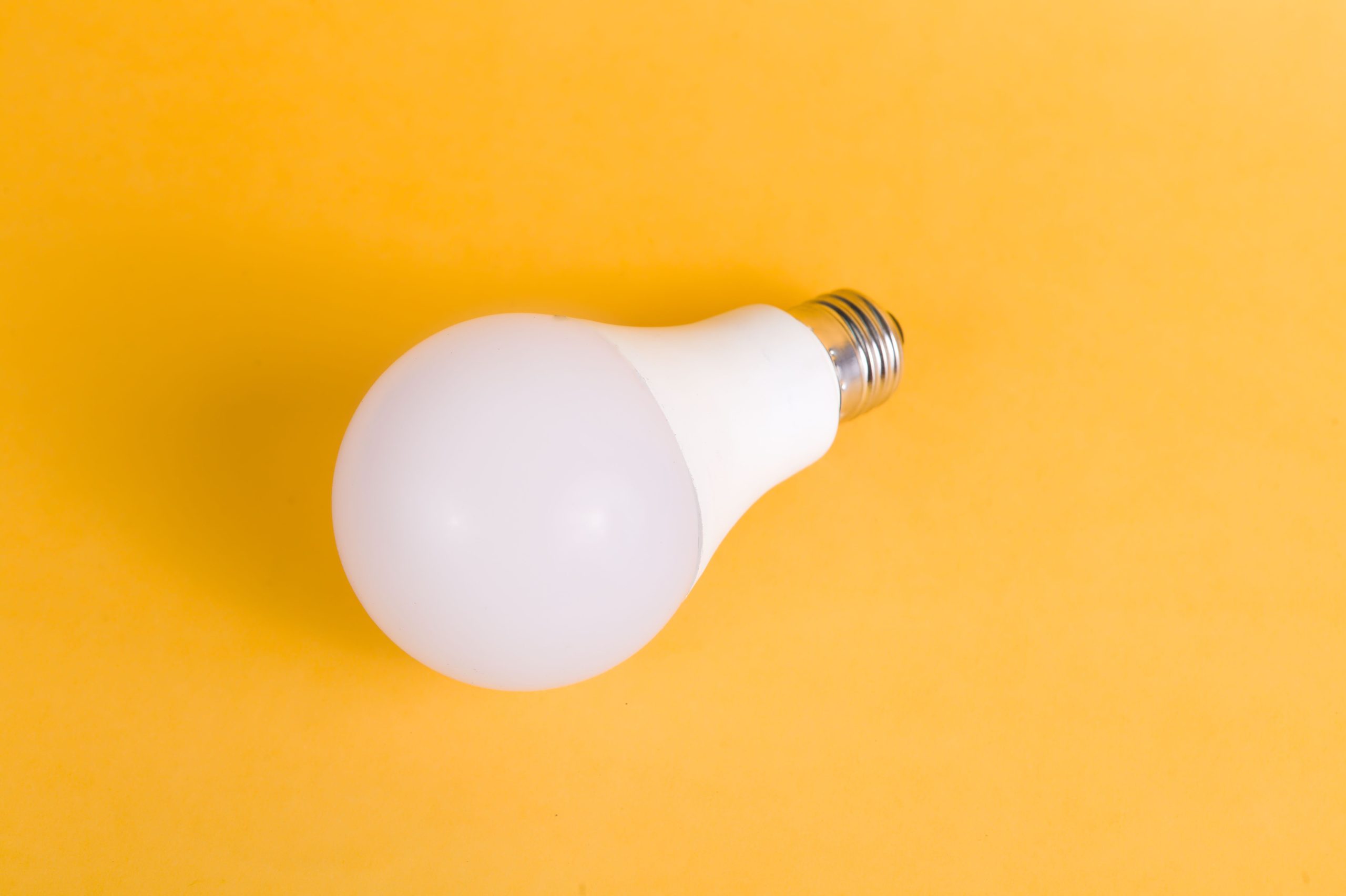 Ampoule LED isolée sur fond jaune minimaliste