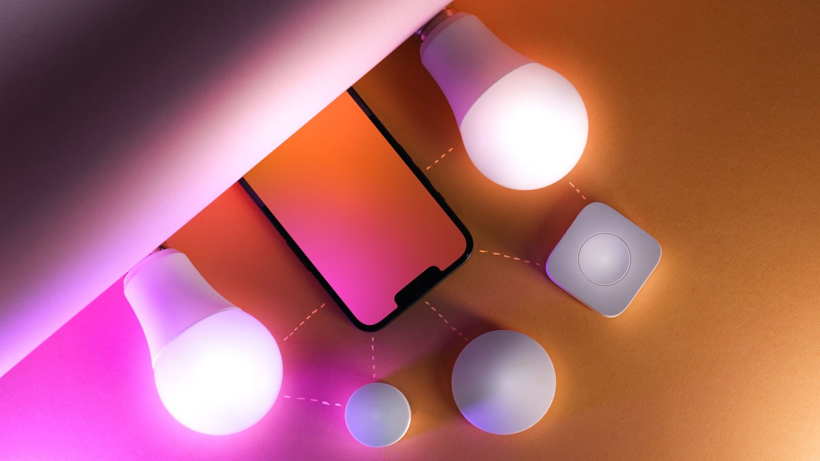 Ampoules connectées et smartphone sur fond coloré