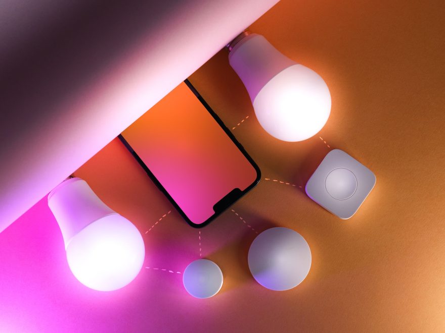 Ampoules connectées et smartphone sur fond coloré
