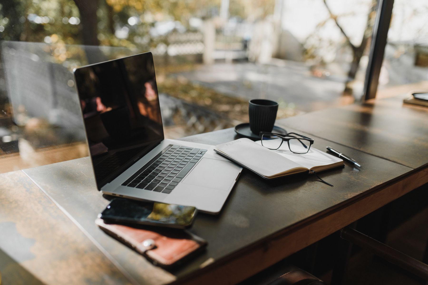 Ordinateur portable, téléphone et bloc-notes sur bureau en bois