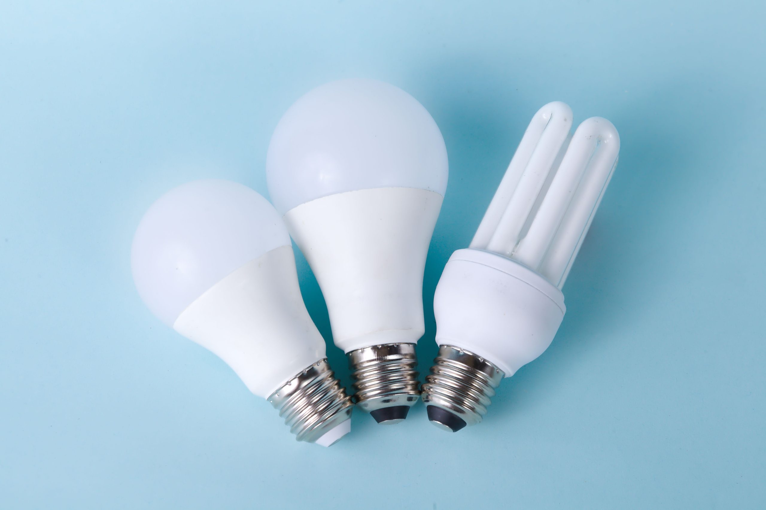 Trois ampoules LED et basse consommation sur fond bleu clair